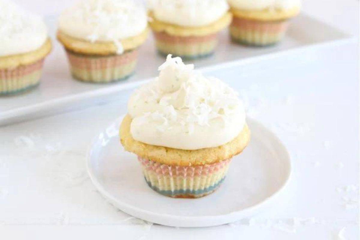 Coconut lime cupcakes on a white serving tray.