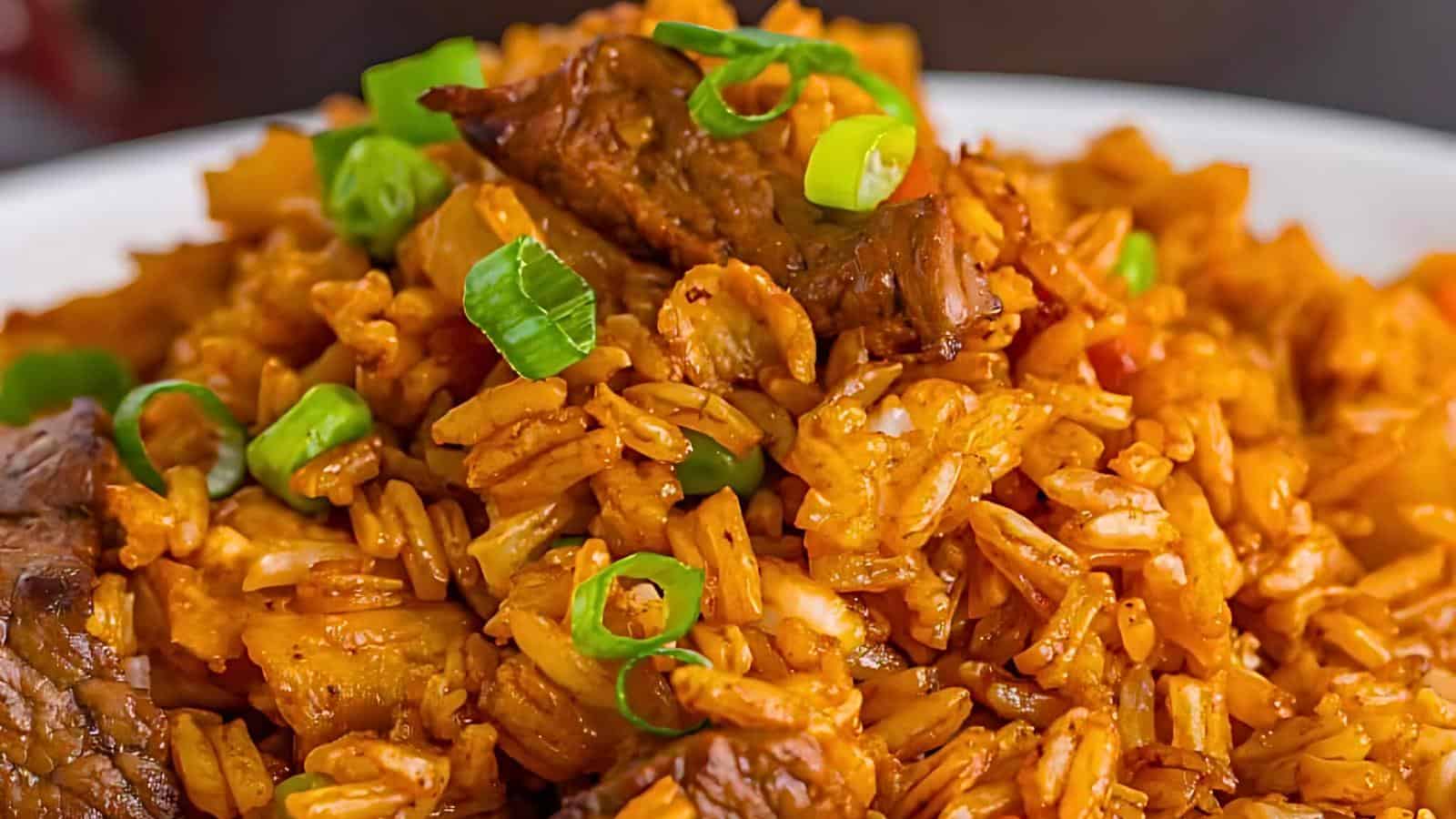 A bowl filled with a vibrant serving of jambalaya, featuring chunks of meat, seasoned rice, and topped with chopped green onions. The dish showcases rich colors and textures, highlighting the ingredients' freshness and the meal's intricate preparation.