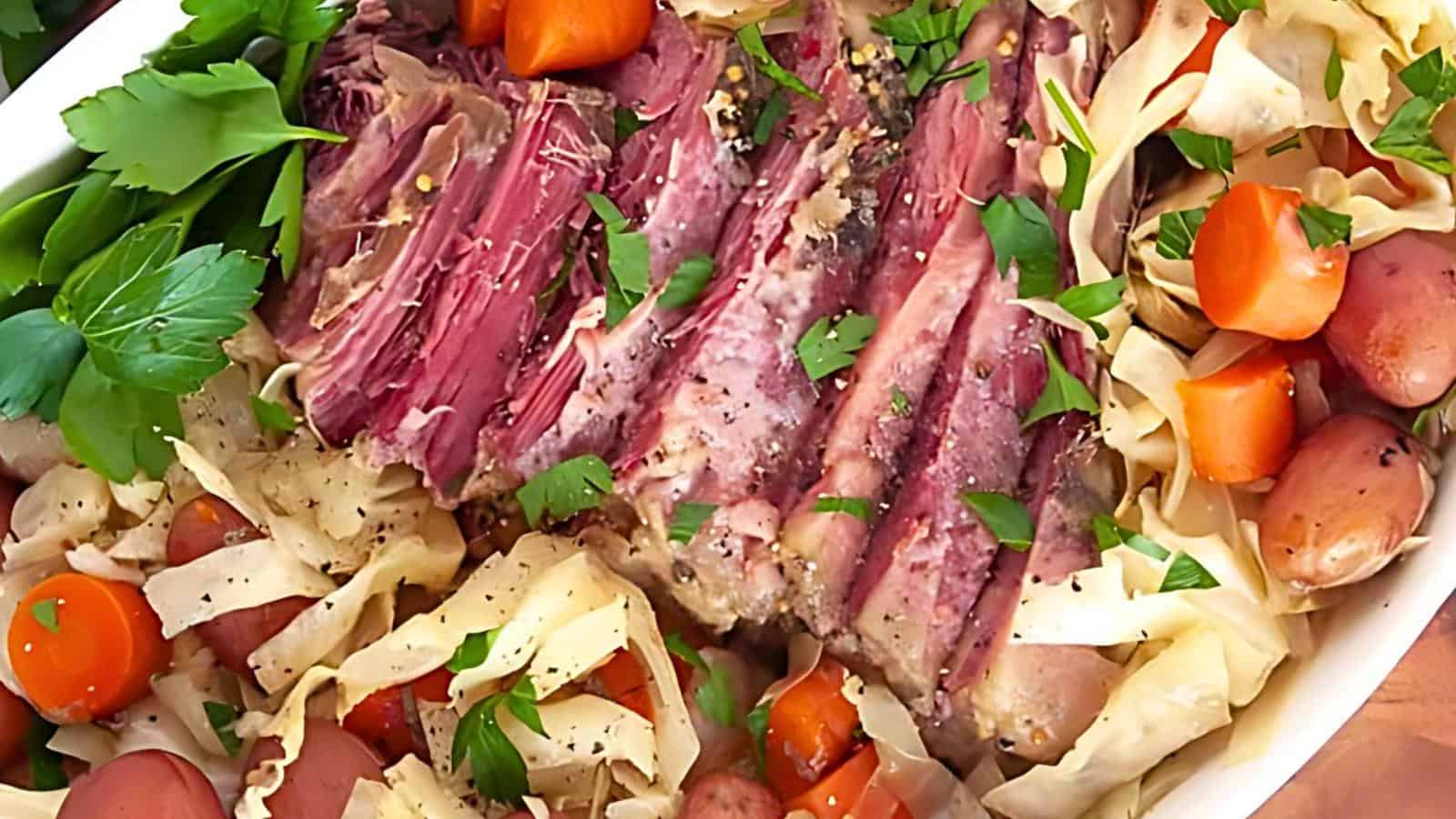 A plate of corned beef with cabbage, sliced carrots, and baby potatoes. The beef is cut into thin strips and topped with fresh parsley. The dish is garnished with additional parsley and arranged in a visually appealing manner.