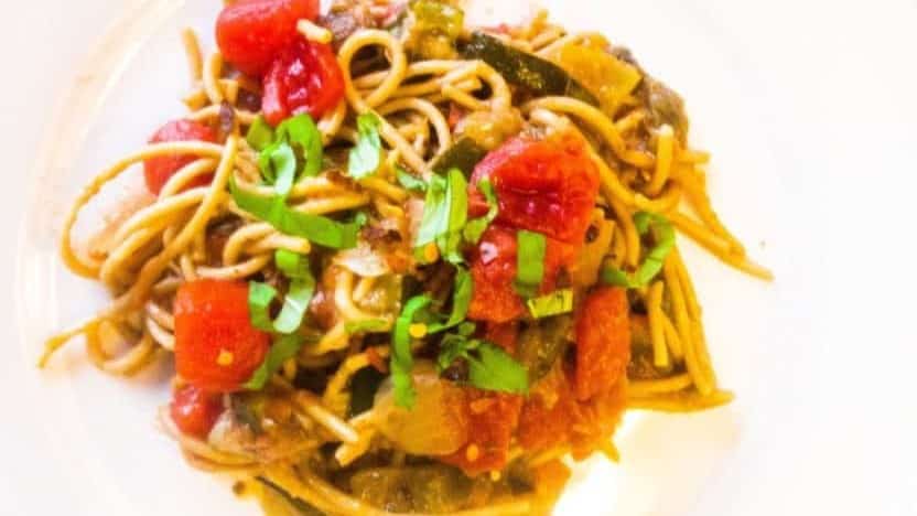spaghetti with chopped tomatoes and eggplant and sliced fresh basil leaves.