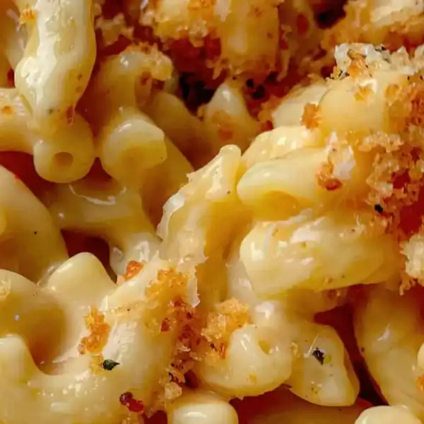 The image shows creamy macaroni and cheese topped with crispy breadcrumbs.