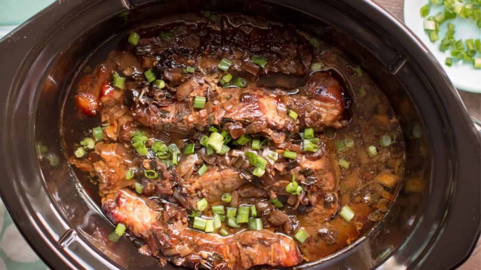 Braised meat covered in sauce, topped with fresh chopped green onions.