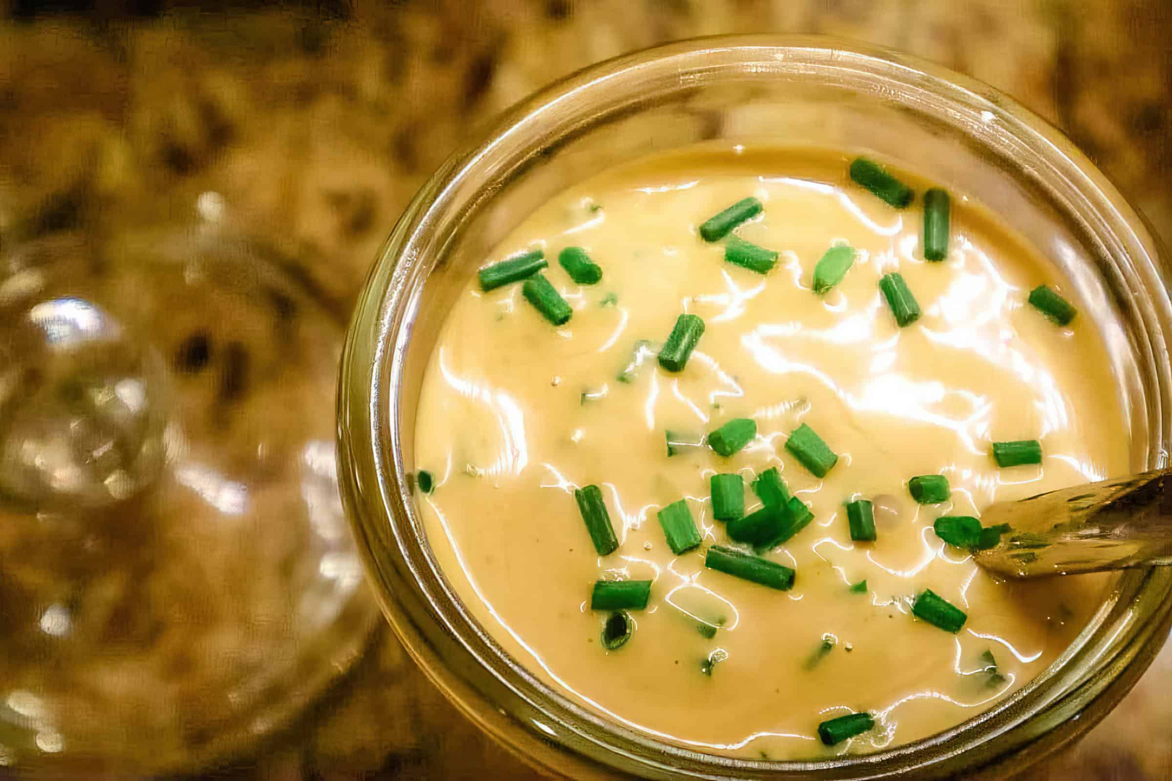 A glass with a liquid with green onions.