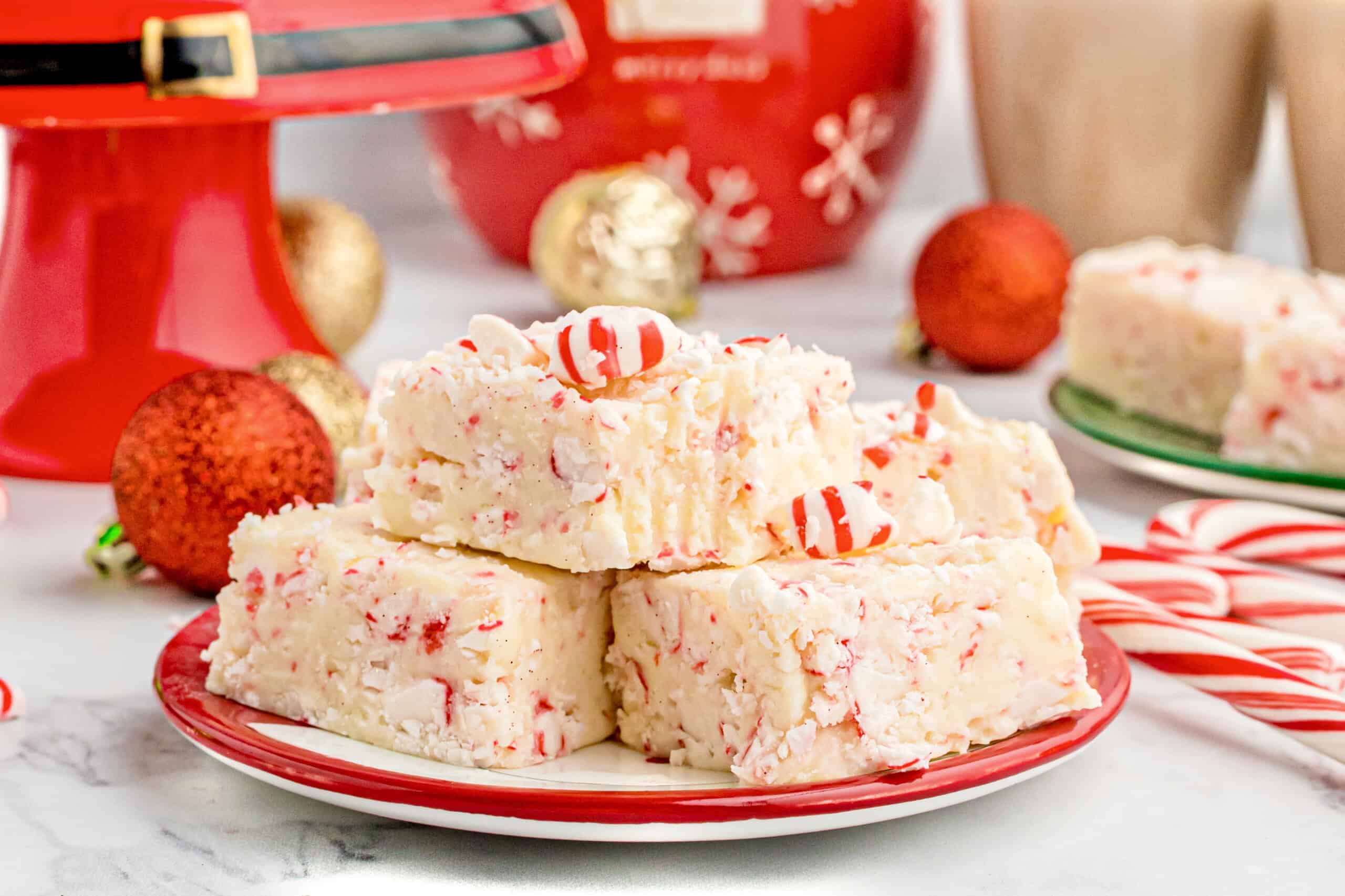 The image shows a plate with three pieces of peppermint fudge topped with striped candy mints.