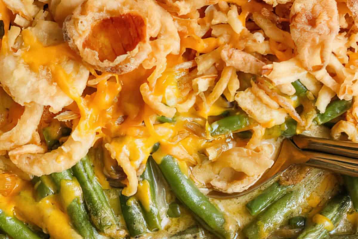 The image features a dish topped with melted cheese, crispy onions, and fried shallots.