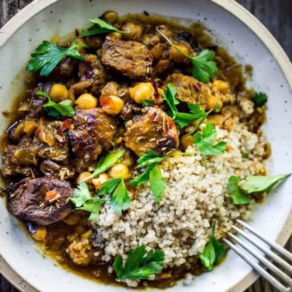 A delicious bowl of chicken and chickpea stew accompanied by couscous, showcasing vibrant colors and rich textures.