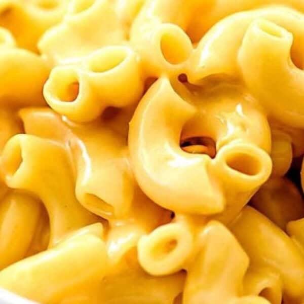 A white bowl filled with macaroni and cheese, featuring elbow pasta coated in a creamy cheese sauce.