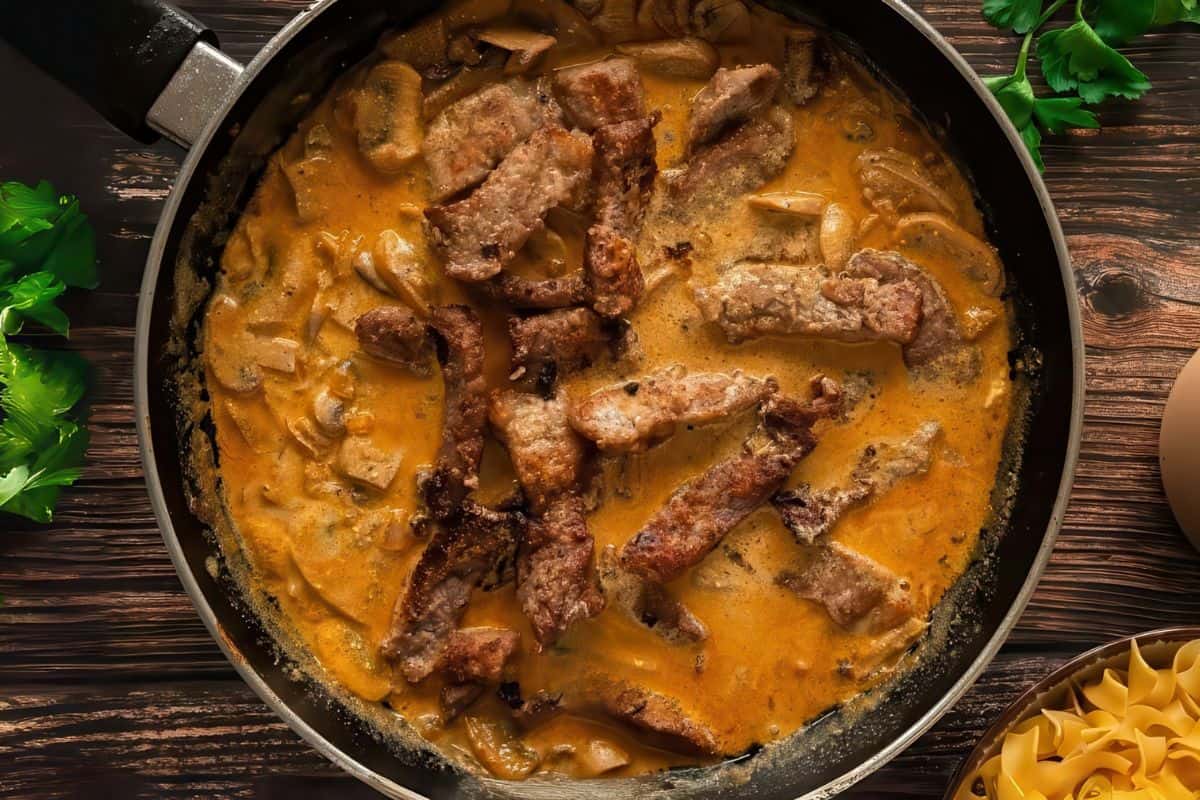 A skillet filled with beef and mushrooms Stroganoff.