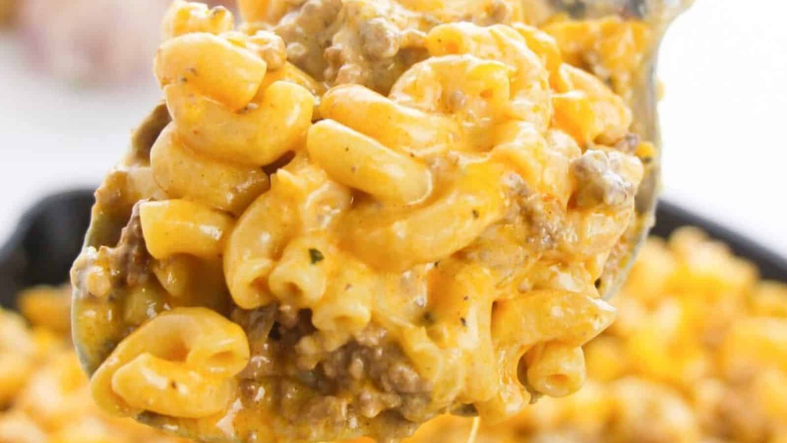 A spoonful of elbow macaroni mixed with ground beef, all coated in melted cheese.