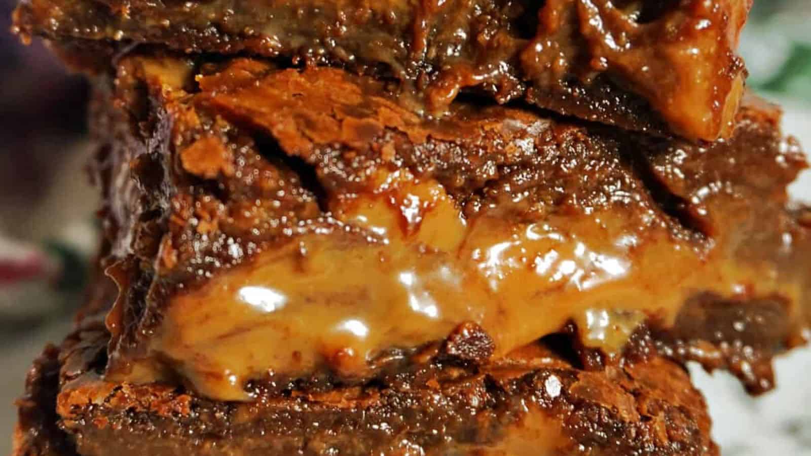 Stacked chocolate brownies with a gooey caramel layer in the middle.