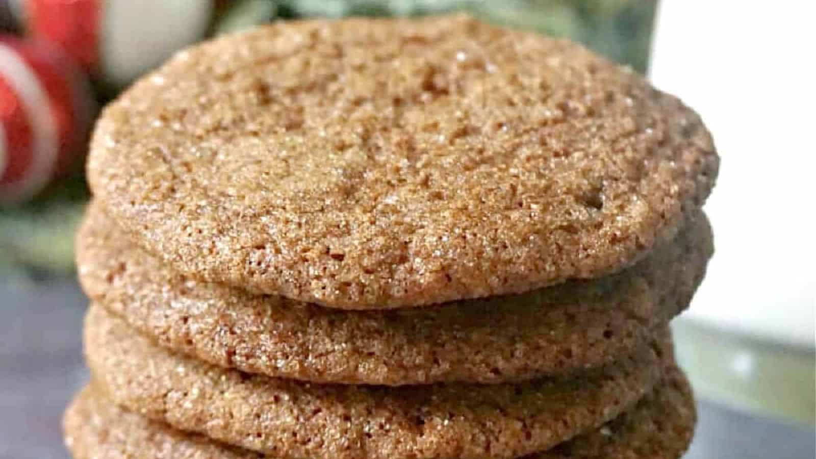 Four brown, sugar-coated cookies stacked on a table.