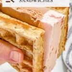 A hand holds a waffle ice cream sandwich with visible layers of strawberry, vanilla, and chocolate ice cream.