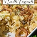 Bowtie pasta in a baking dish topped with crispy fried onions and chopped parsley.