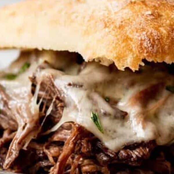 Shredded beef and melted cheese inside a toasted bun, shown in close-up.