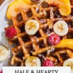 A plate of waffles topped with banana slices, raspberries, peach slices, and syrup. Text reads "HALE & HEARTY Waffles.