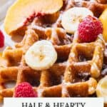 Waffles topped with banana slices, raspberries, peach slices, and powdered sugar. Text: “Hale & Hearty Waffles.”.