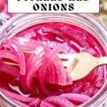 Sliced pickled red onions in a glass jar with a wooden fork and a label reading "Sweet and Spicy Pickled Red Onions.
