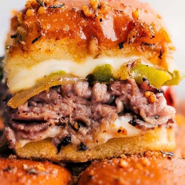 Sandwich slider with roast beef, melted cheese, pickles, and a seasoned bun.