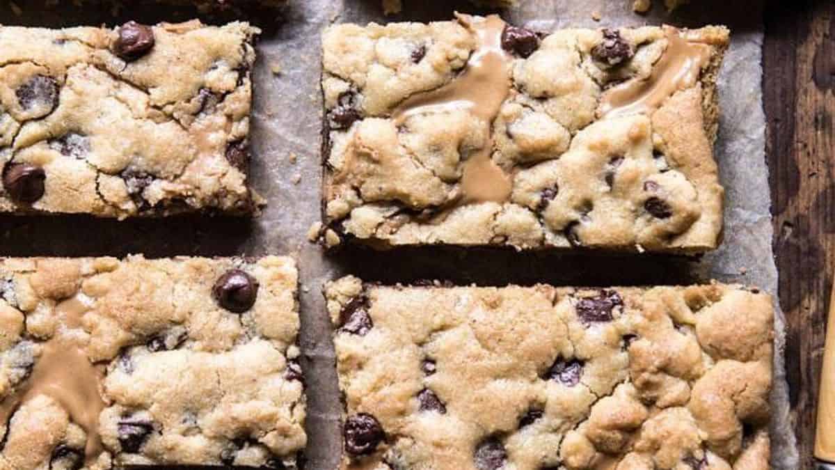Rectangular chocolate chip cookie bars on a parchment-lined baking sheet.